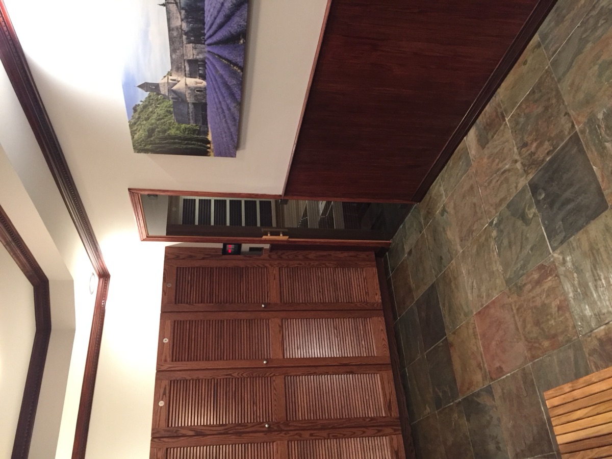 Wood-paneled locker room with sauna entry visible