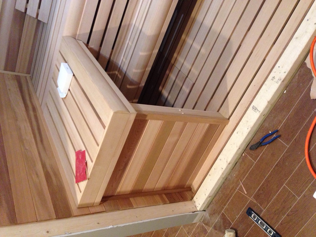 Sauna with two-tier bench seating and recessed lighting